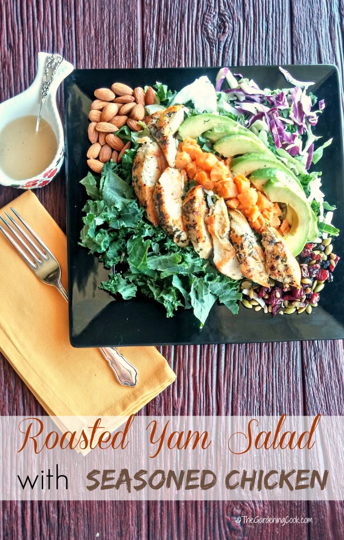 Vegetable and chicken salad on a black plate with a yellow napkin and fork and words Roasted Yam Salad with Seasoned Chicken.