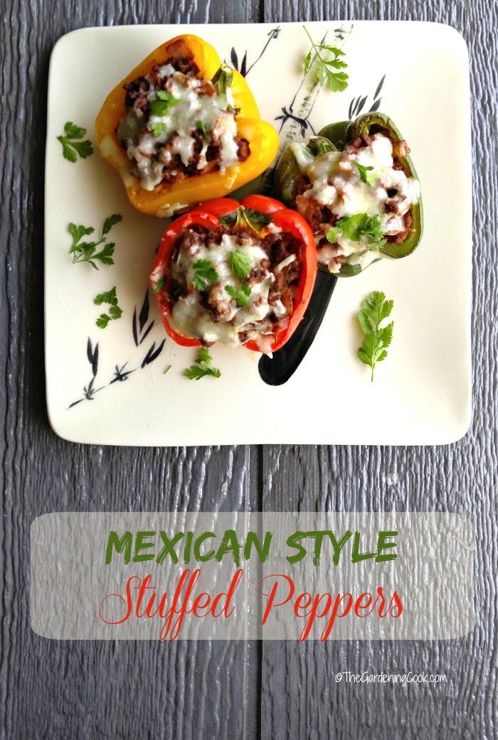 Stuffed peppers on a plate with herbs and words reading Mexican Style Stuffed Peppers.