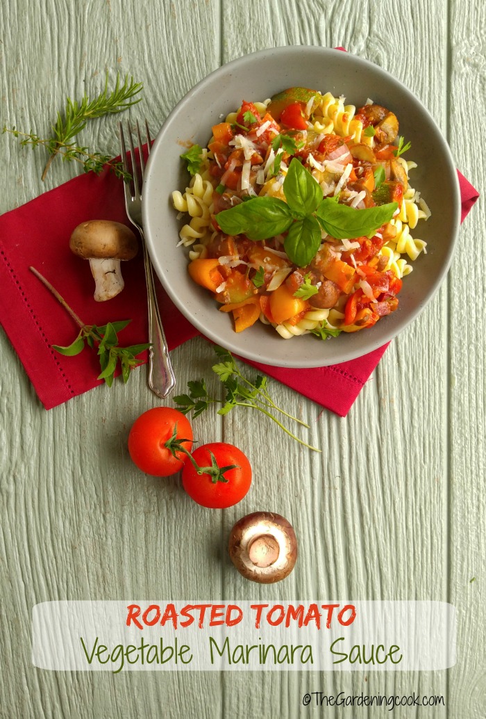 Bowl of pasta and vegetables with tomatoes, napkin, fork and mushrooms and words reading Roasted Tomato Vegetable Marinara Sauce.