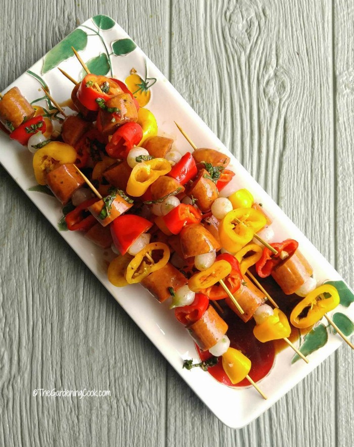 Cajun style Andouille sausage kebabs on a long plate.