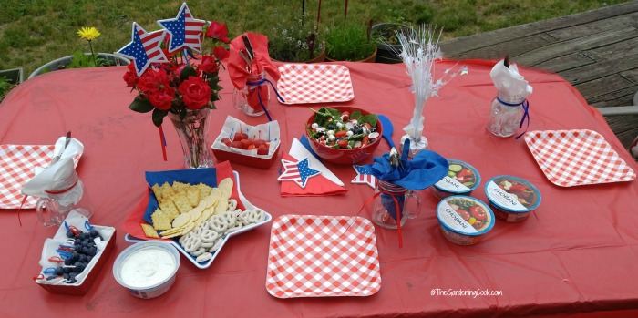Patriotic Tablescape for the fourth of July on a red table outdoors.
