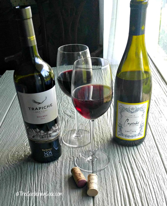 Two bottles of wine with corks and glasses. 