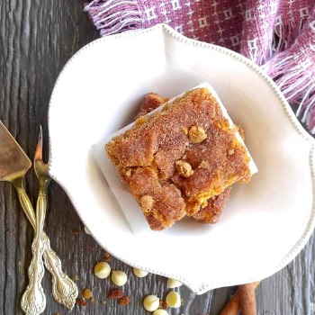 Snickerdoodle bars un a white bowl with fork and knife.