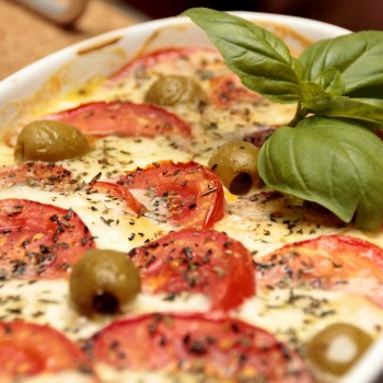 Tomato and olive casserole with cheese and basil.