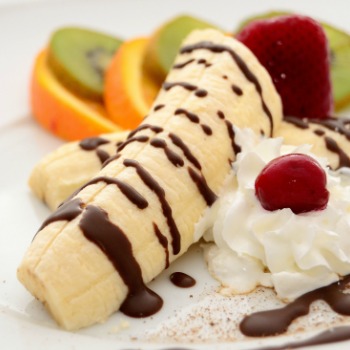 Banana and fruit with whipped cream and chocolate.