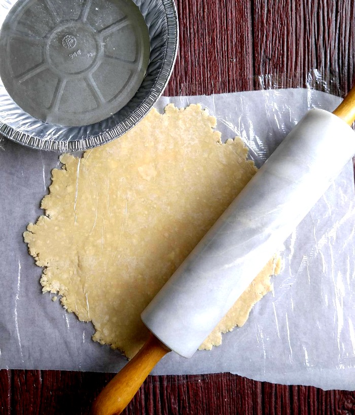 parchment paper under pie crust Roll out pie dough on parchment paper to keep your counters clean and make transferring it to the dish easier.