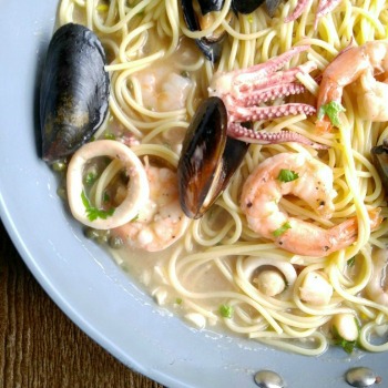 Seafood and angel hair pasta recipe in a gray bowl.
