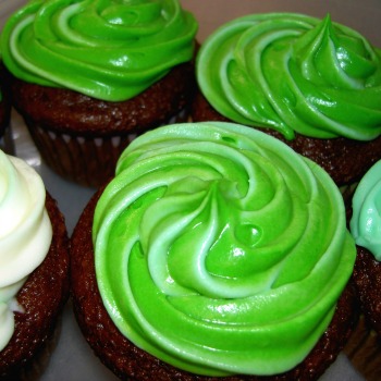 Green frosting on chocolate cupcakes.