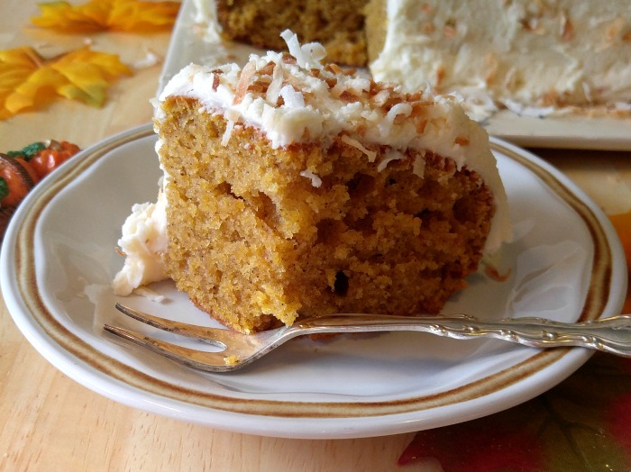 .Pumpkin spice cake on a white plate with a fork.