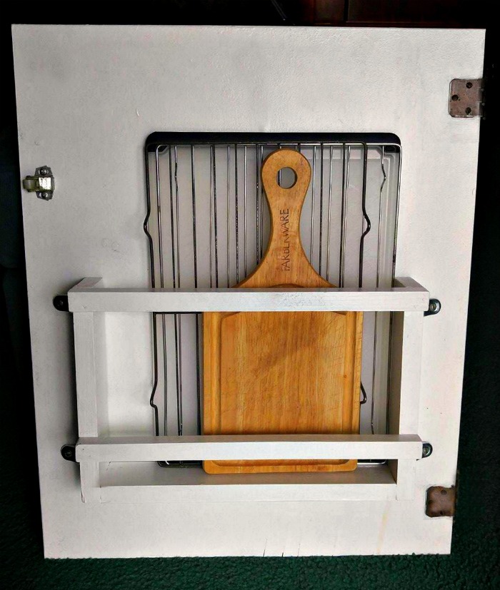 The cutting board holder is attached to the cabinet door