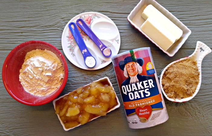 Rolled oats, spices, flour, apples, brown sugar and butter in bowls.