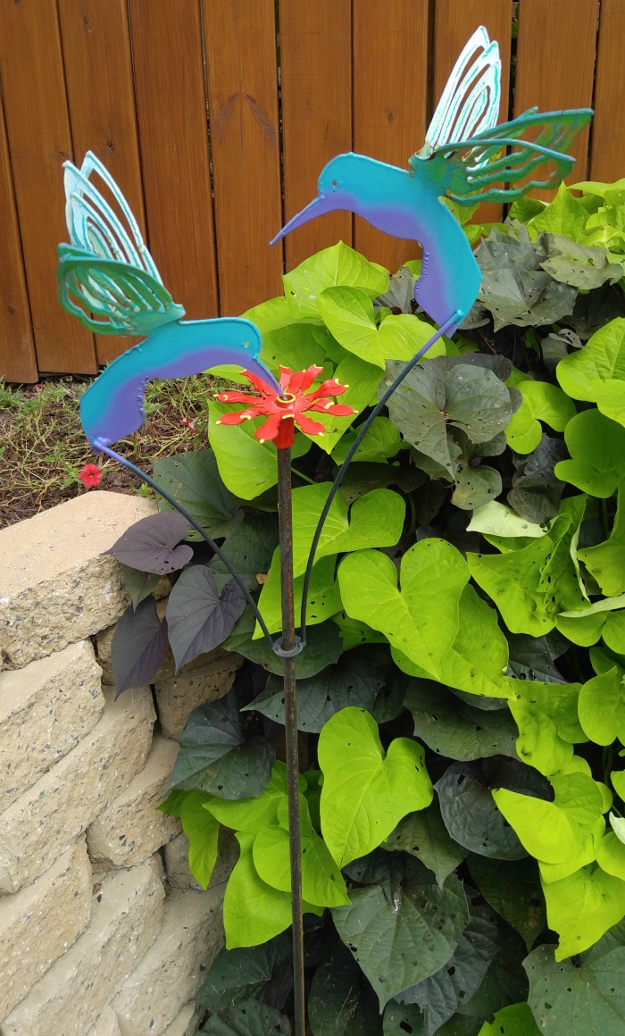 Metal yard art hunningbirds with tiny hummingbird feeder