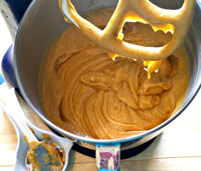 Cake batter in a mixing bowl with a spatula in a spoon rest.