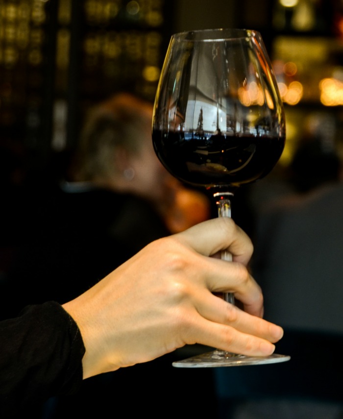 Female hand holding a glass of red wine.