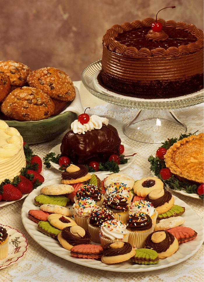 Cake, muffins, sweet treats and other Christmas food on plates.
