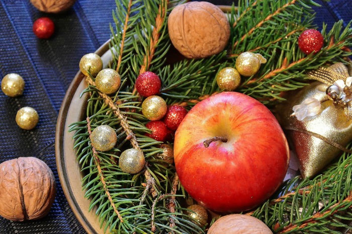 Outdoor greenery with nuts and fruit on a plate.