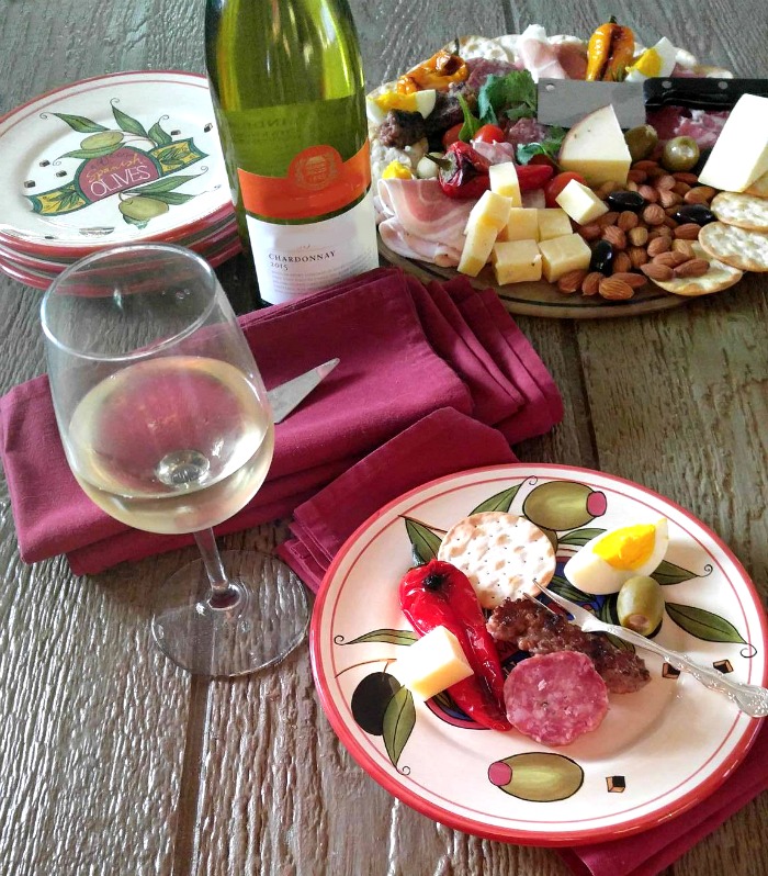 Antipasto served on specialty appetizer plates with wine