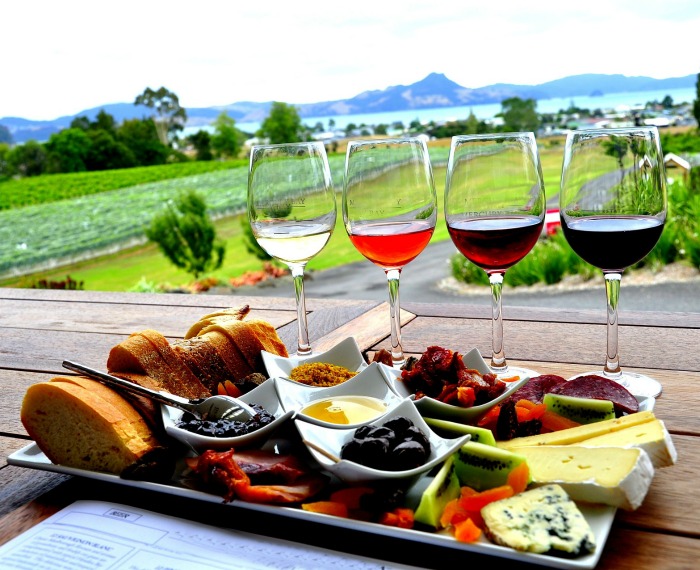 Antipasto platter and glasses of wine in an outdoor setting.