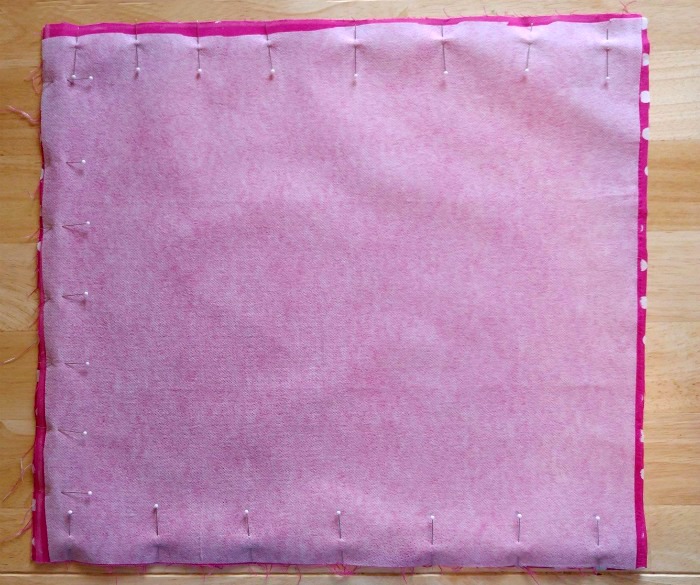 Fusing on one piece of pink fabric pinned in place.