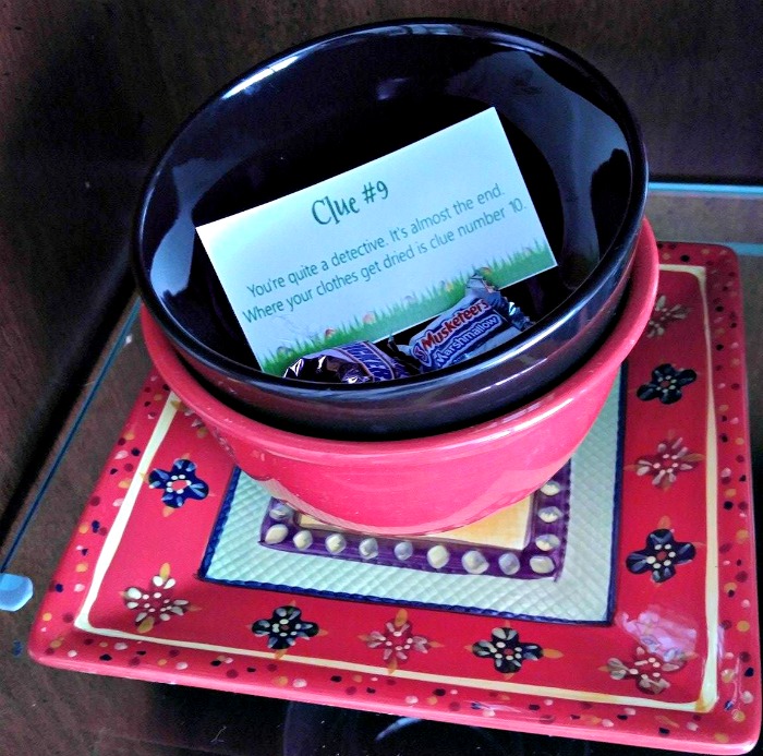 Red plate and black and red bowls with Easter candy and clue.
