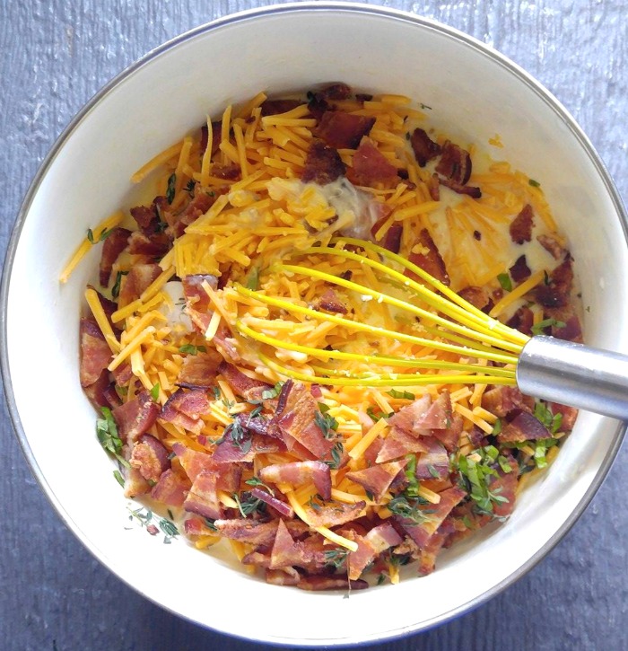 Bowl with bacon, eggs cheese and herbs Mixture for the crustless chicken quiche