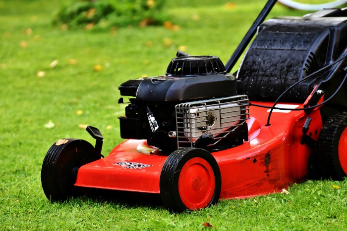 red lawn mower mowing a lawn.