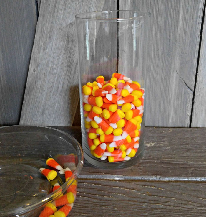 Add candy corn to a glass vase