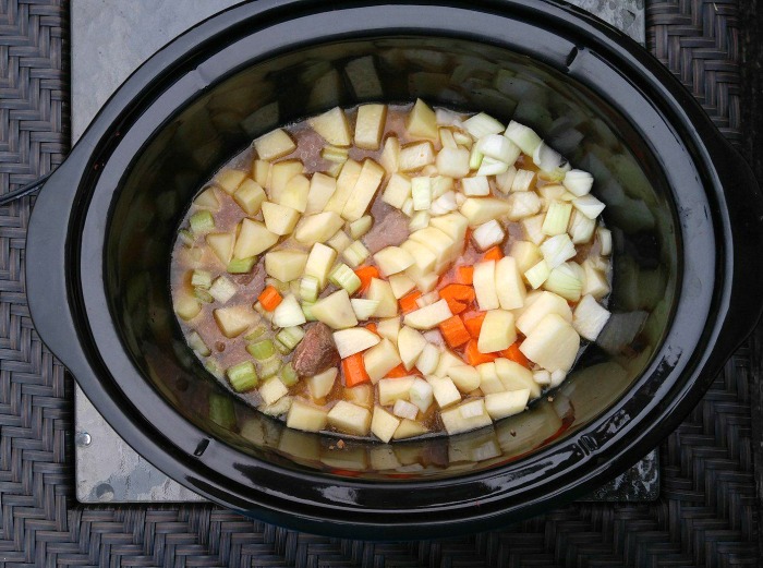 Soup vegetables and broth in a slow cooker