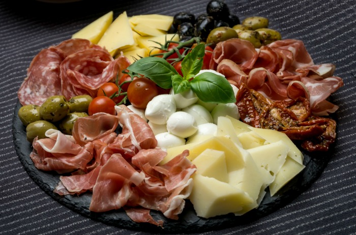 Antipasti platter loaded with meat and cheese.