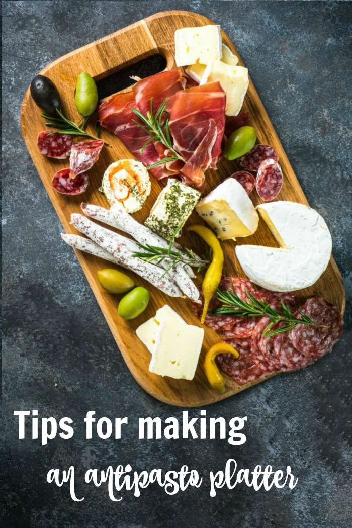 Antipasto platter on a slate counter with text reading "Tips for making an antipasto platter."