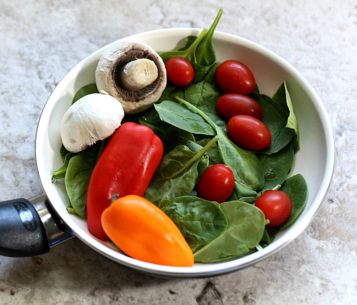 Colorful vegetables and spinach make the base of a breakfast skillet recipe.