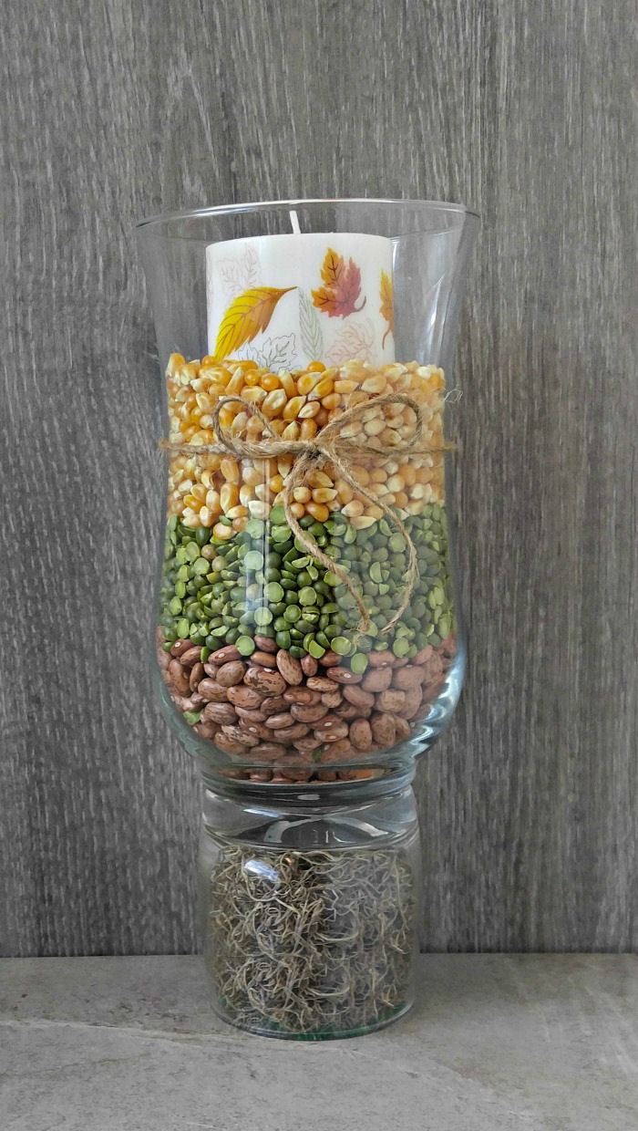 Hurricane lamp died beans, popcorn and a candle on top.