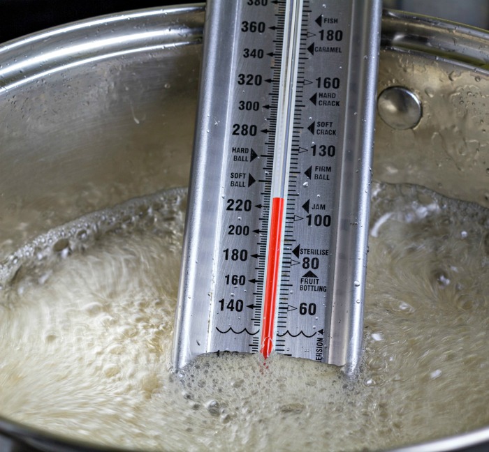 candy thermometer in a pot of sugar.