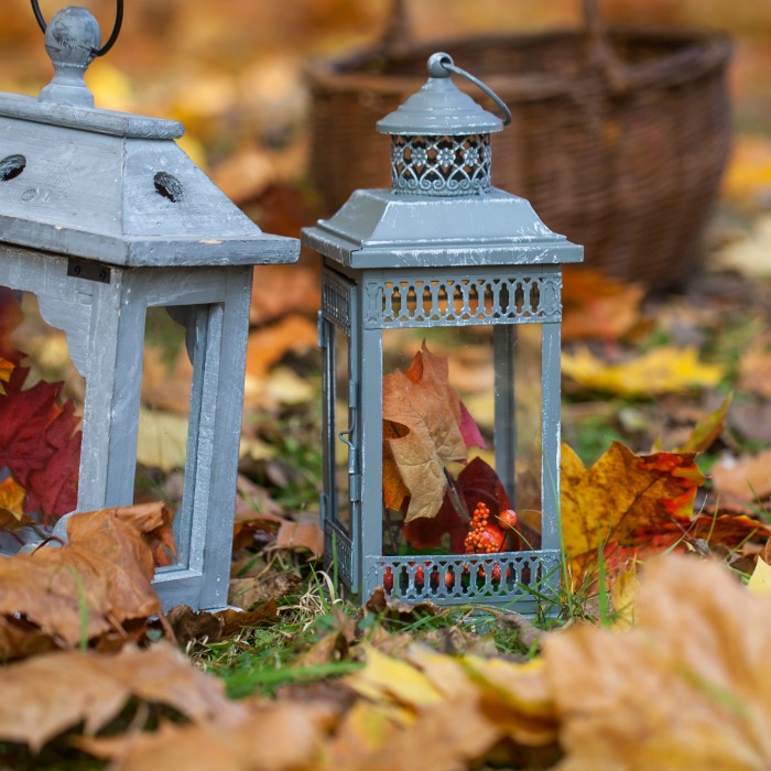 Fall lanterns with leaves and pinecones.