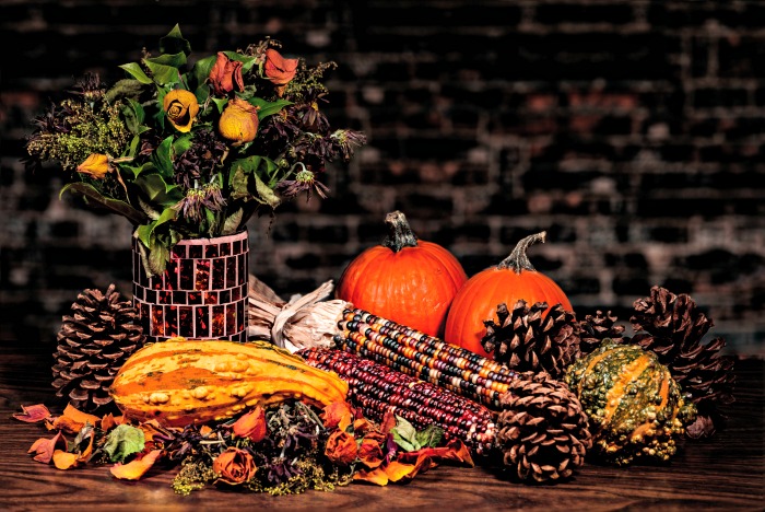 Indian corn and other fall greenery items on a table.