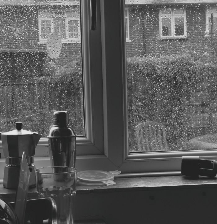 A kitchen window with rain outside.