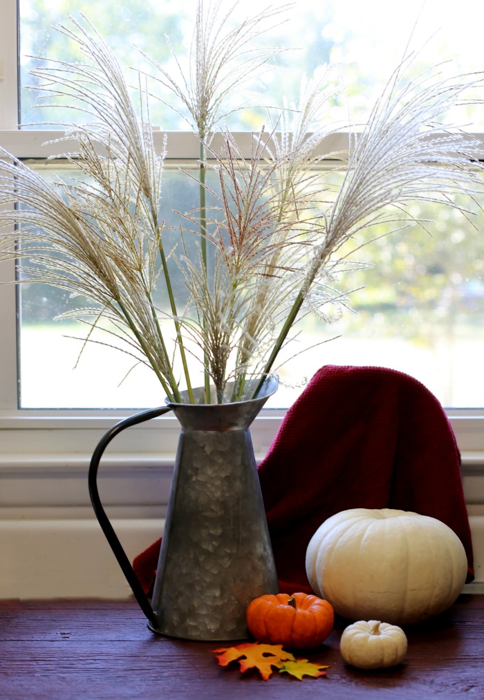 Decorating with natural elements: Silver Grass fronds in a galvanized pitcher with pumpkins
