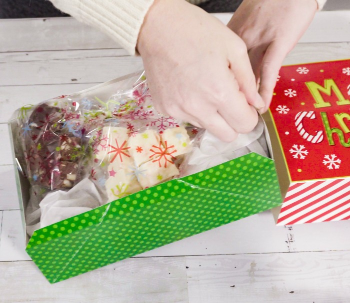 Wrapping fudge in plastic in a Christmas gift box.