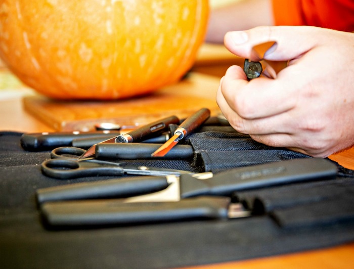 Pumpkin carving tools Set of pumpkin carving tools, mans hand and pumpkin.