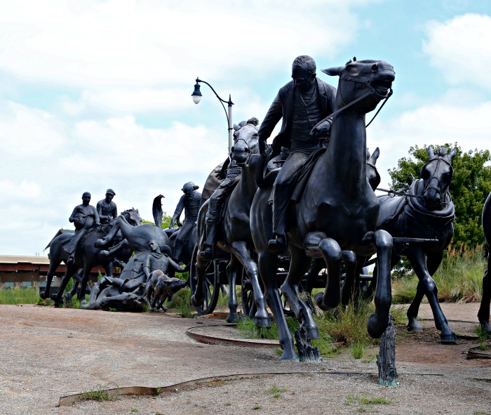 Wagon train made of bronze statues