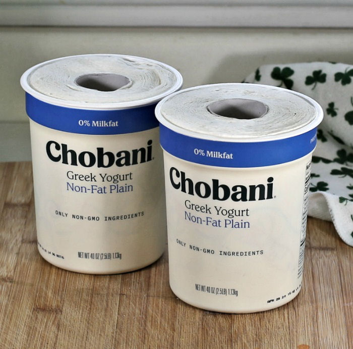 Two Chobani containers with paper towels in them.