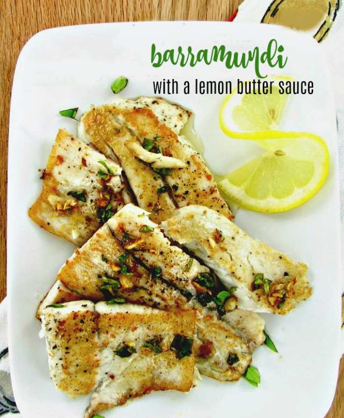 Cooked fish and lemon with words Barramundi with a lemon butter sauce.