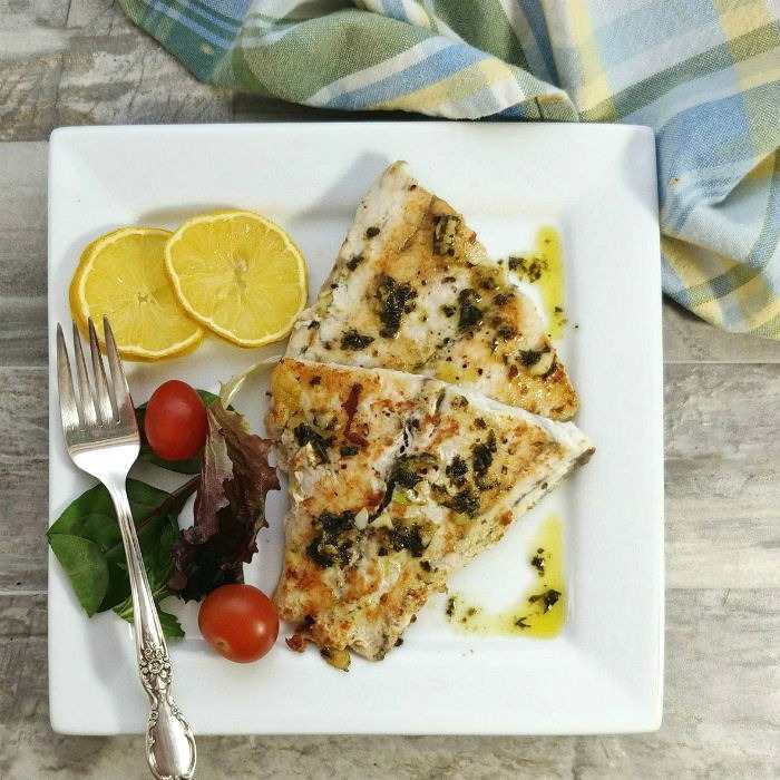 Barramundi recipe on a white plate with salad.