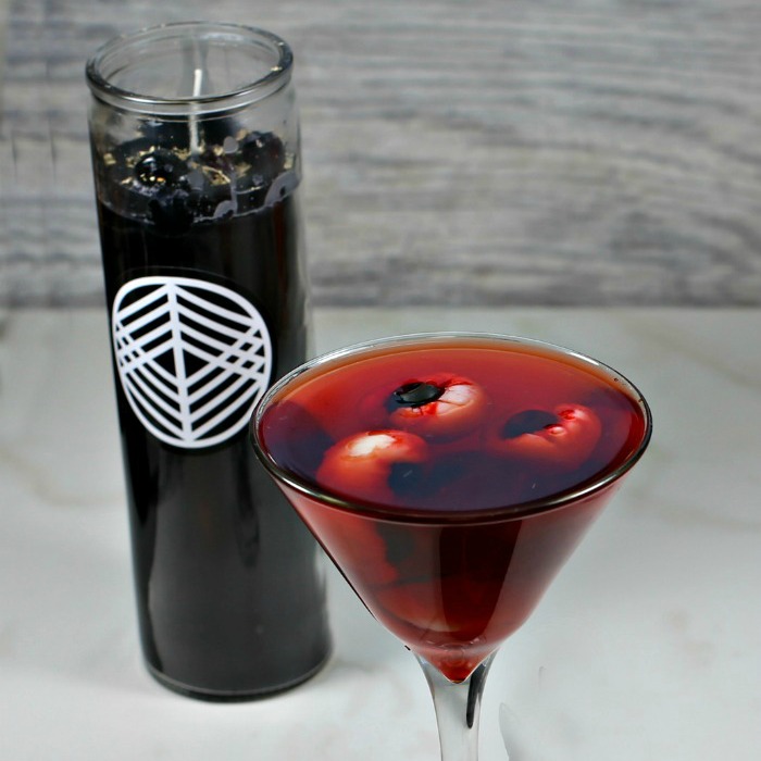 Crows blood cocktail and black candle with lychee eyeballs.