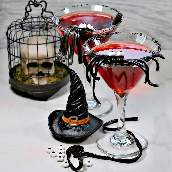 Halloween cocktail garnishes - Licorice spider Halloween cocktail with skull and witches hat.