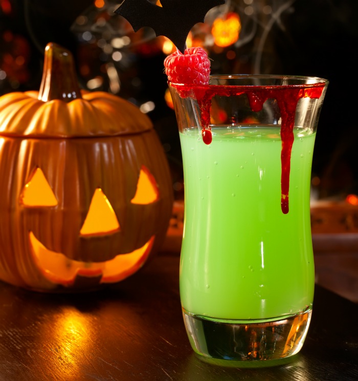 Halloween cocktail special effects - Bloody glass rim on a green drink with a pumpkin.