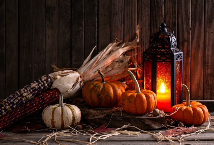 Indian corn display with lantern and pumpkins.