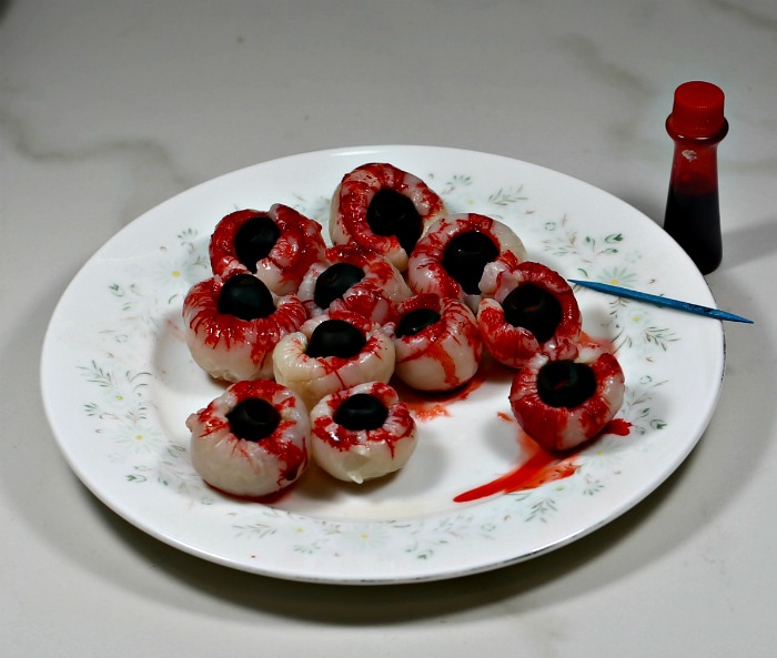 Lychees stuffed with black olives and red food coloring to make bloody eyes.