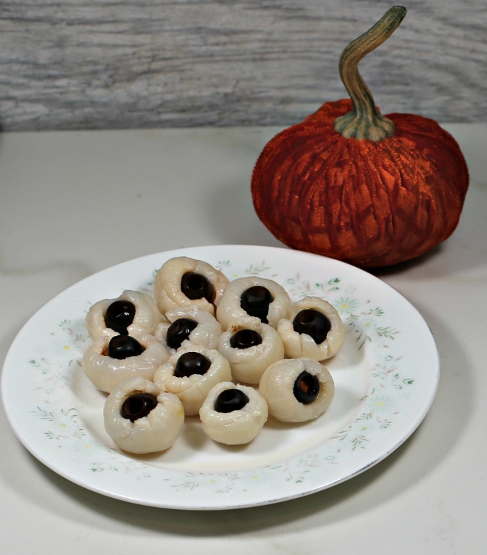 Lychees stuffed with black olives and an orange pumpkin.