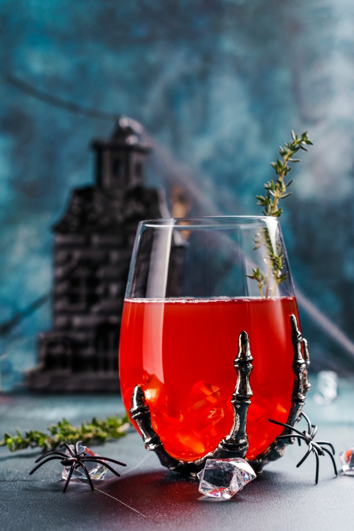 Skeleton hand goblet with cranberry juice and spiders.